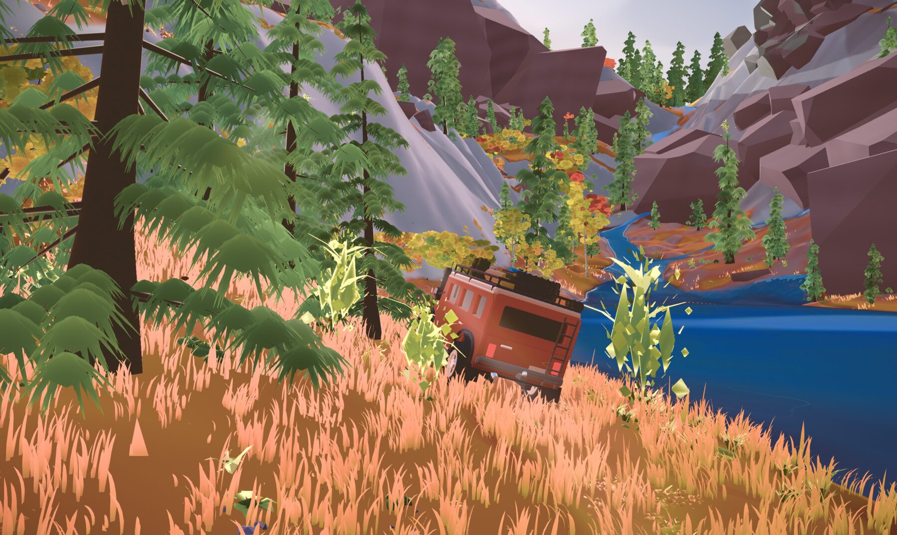 A red camper driving through tall autumn grass beside a river, leaves flying up