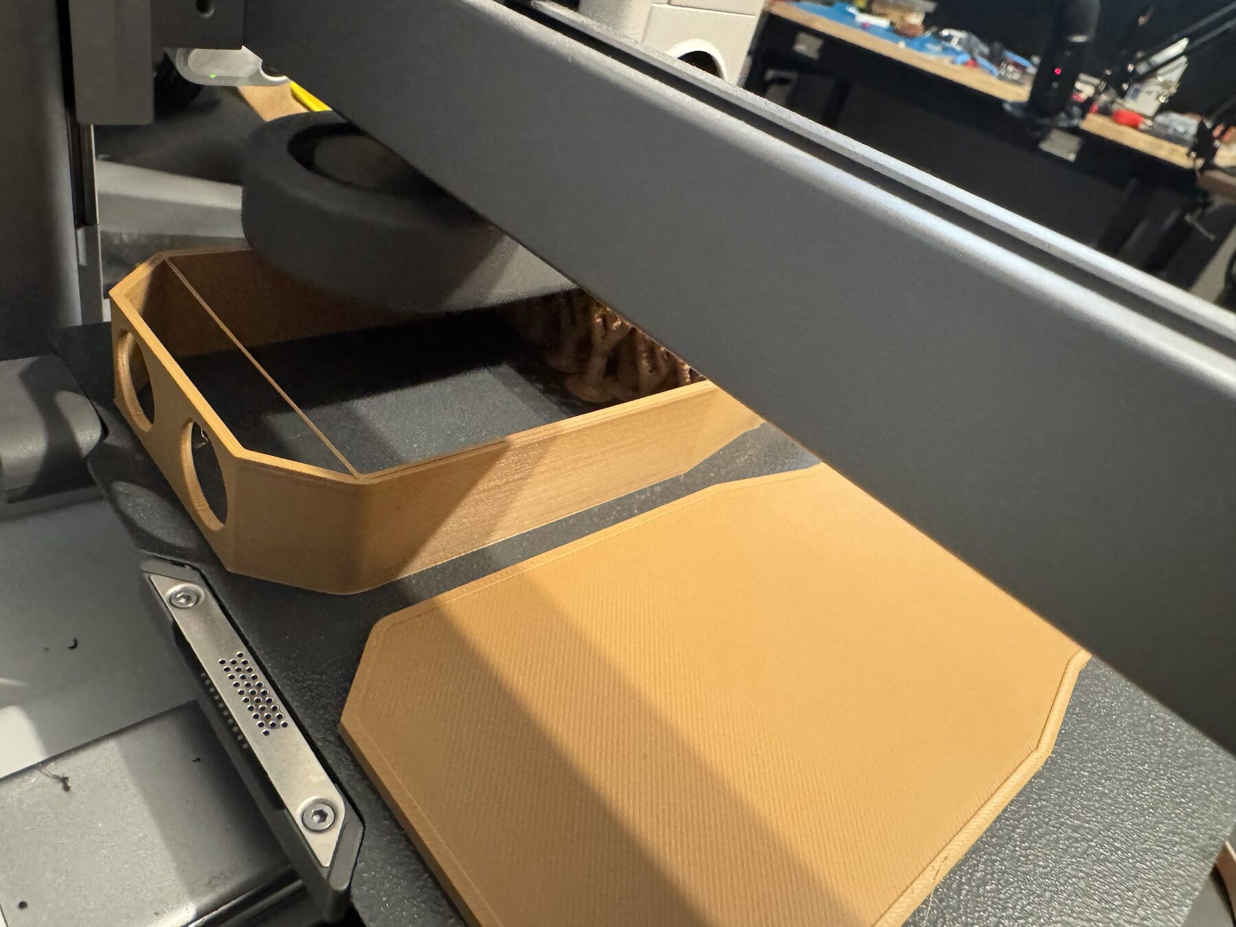The tan case printing on the 3D printer bed