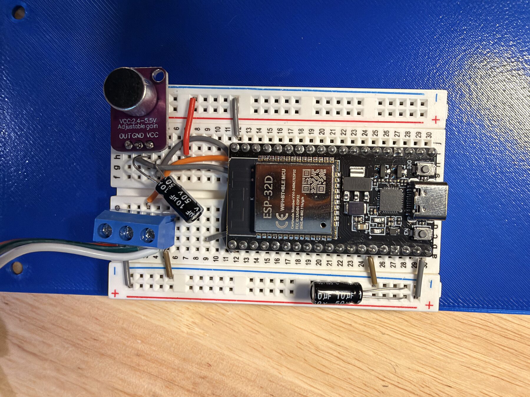 ESP32 on a breadboard with the mic module, capacitors and a screw terminal