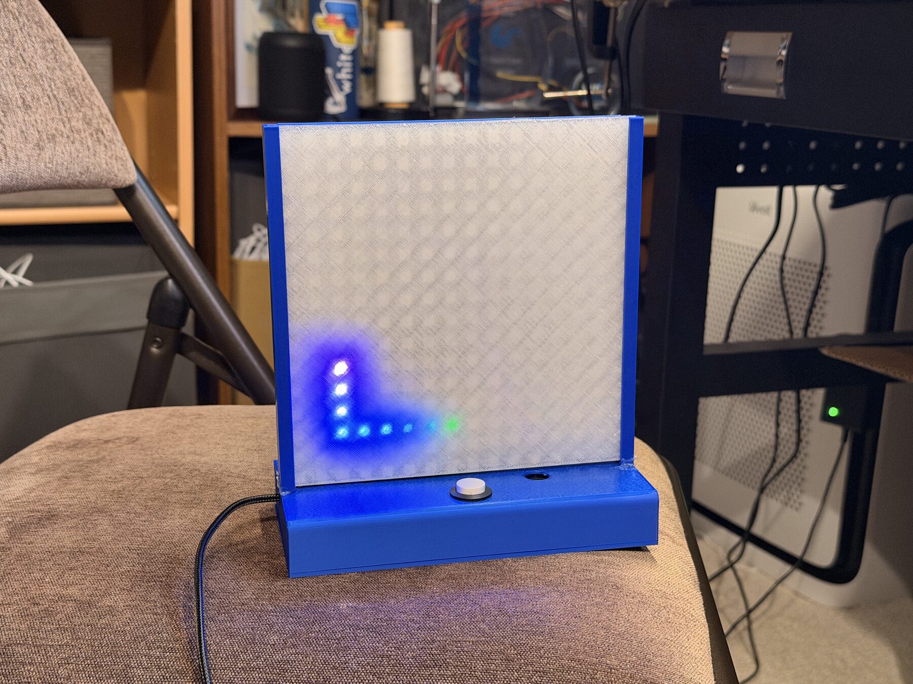 The toy on a chair showing a small blue and green pixel drawing in one corner