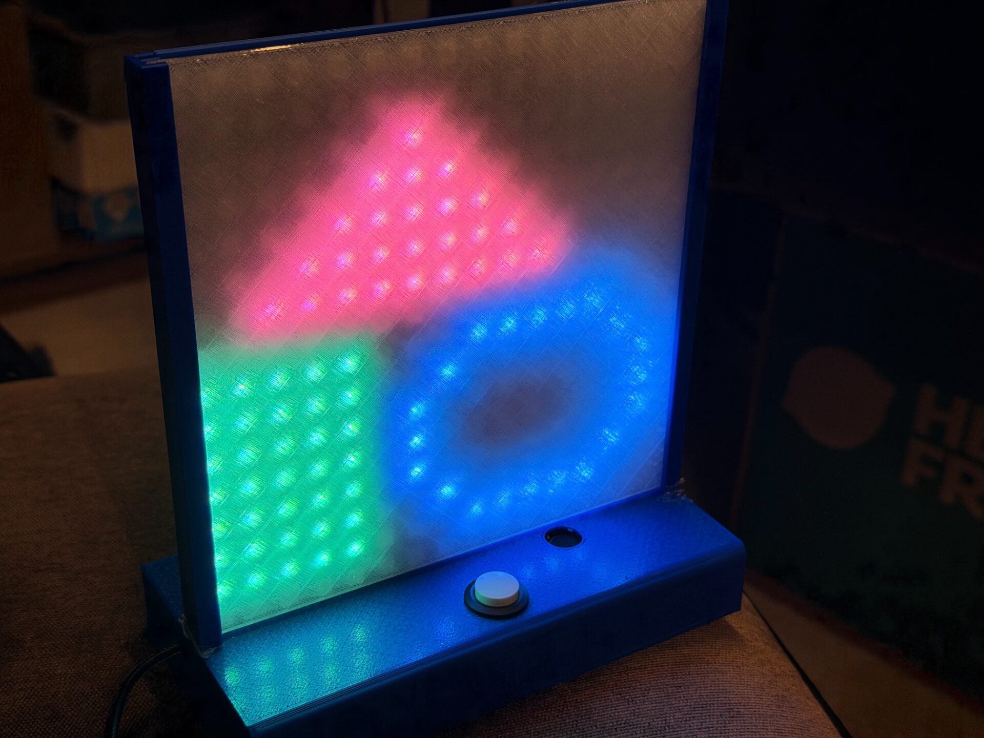 The toy in a dark room showing a pink triangle, green square and blue ring